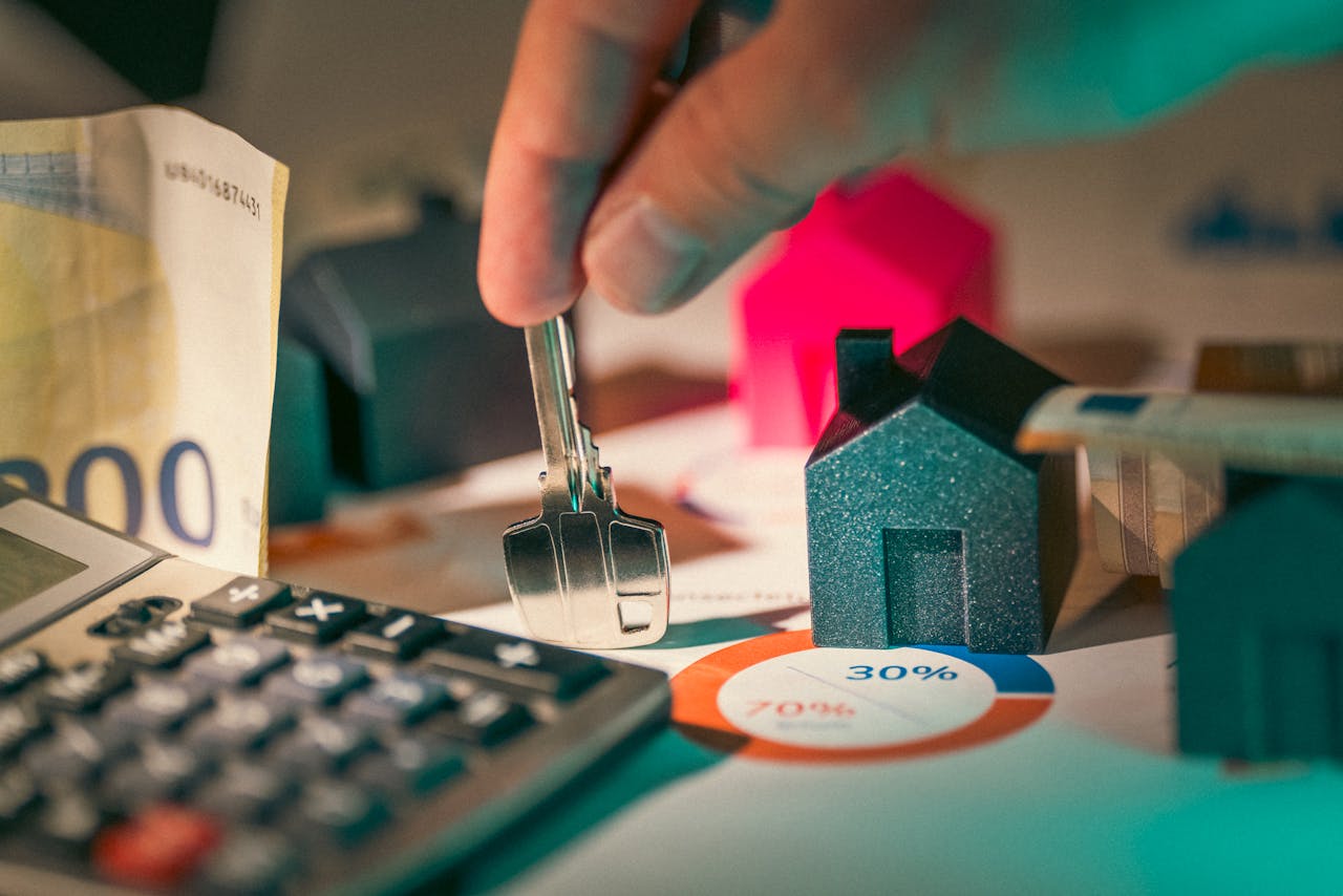 services-04 A close-up of real estate financial planning with keys, calculator, and money.