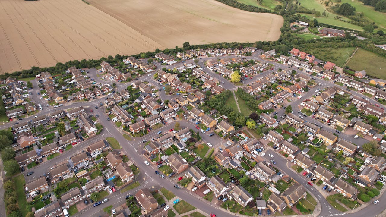 Aerial view of a suburban residential area in Luton, England, showcasing well-planned housing and green spaces.